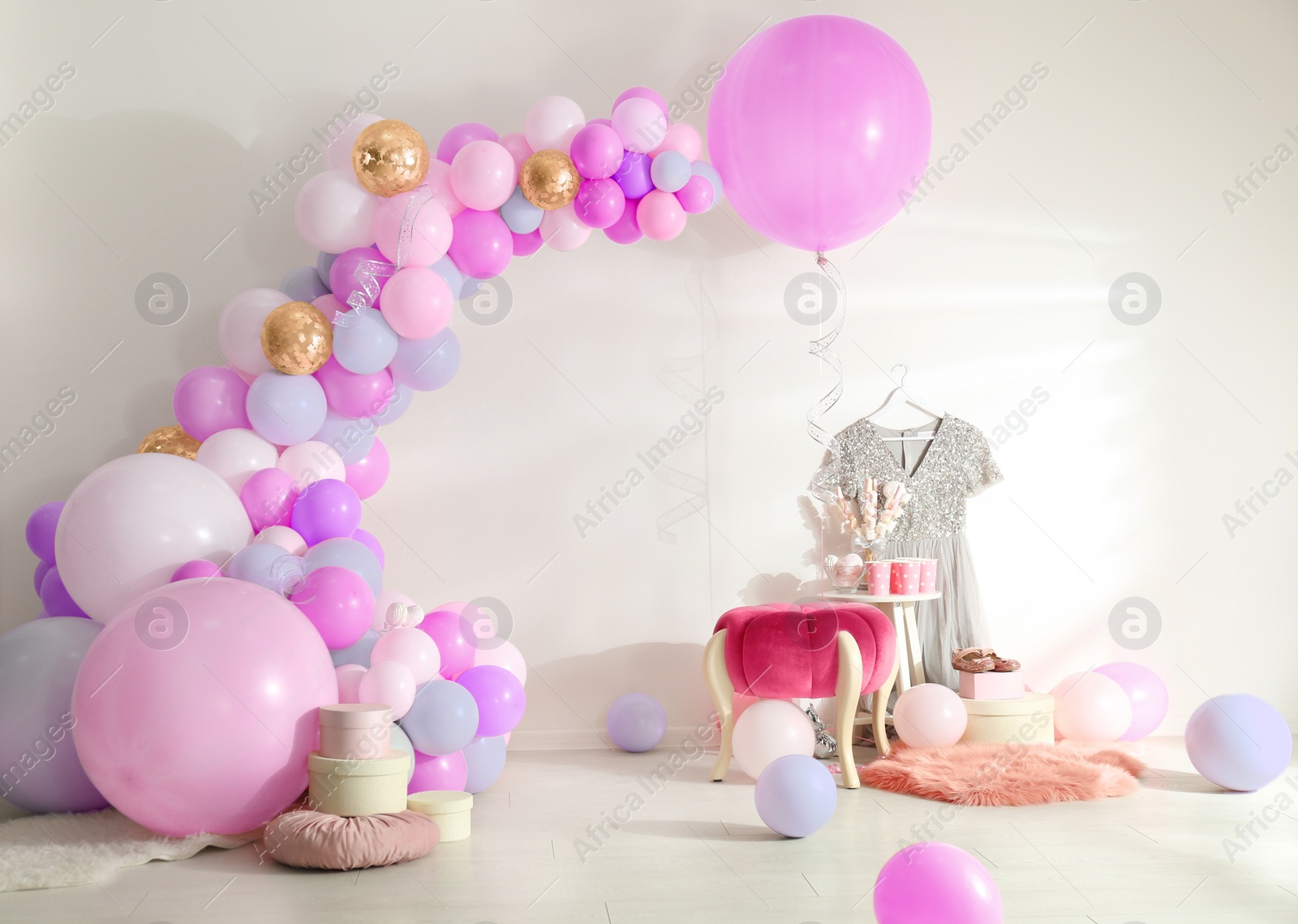 Image of Balloon garland near white wall in room. Festive decor