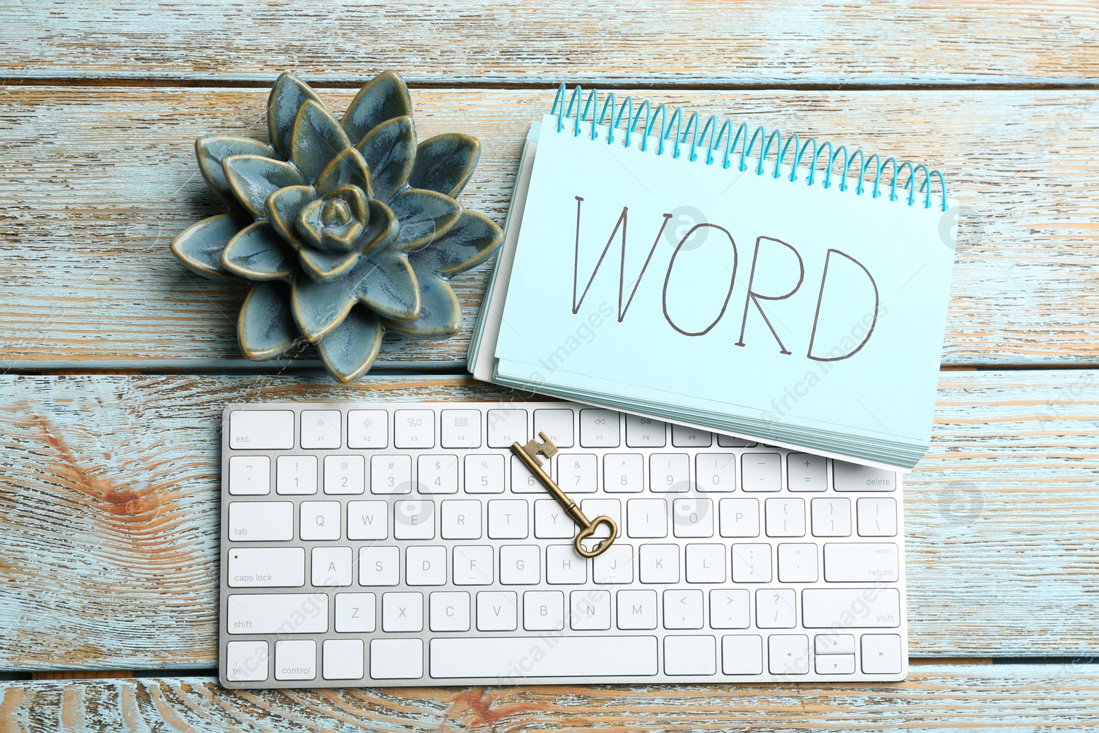 Photo of Composition with key, notebook and computer keyboard on wooden table, flat lay. Keyword concept