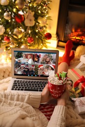 Image of Young woman having online meeting with family members via videocall application at home, closeup