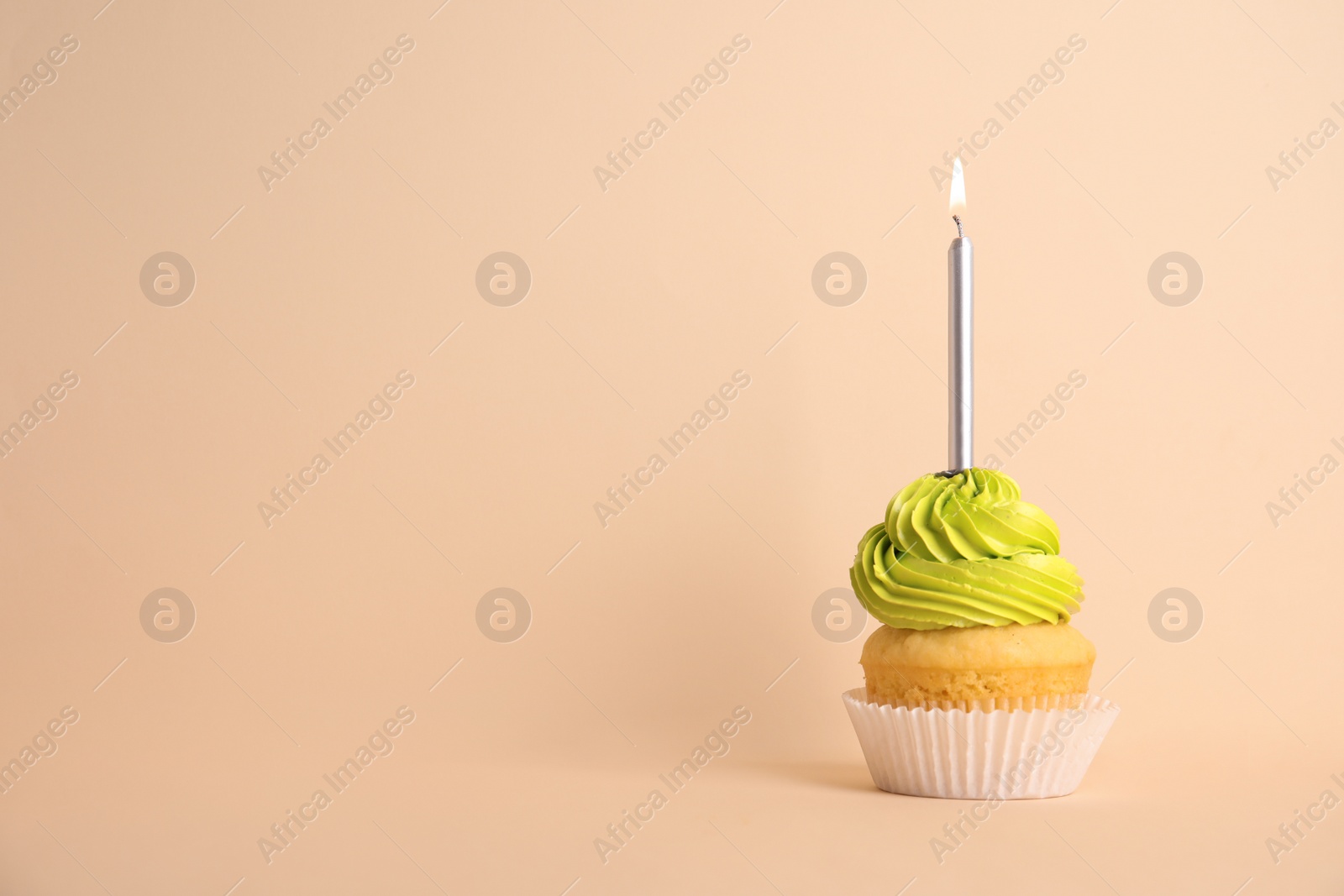 Photo of Birthday cupcake with candle on beige background, space for text