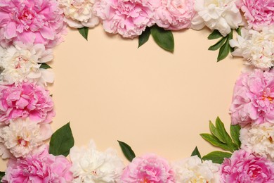 Photo of Frame made of beautiful peony flowers and green leaves on beige background, flat lay. Space for text