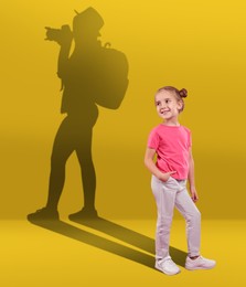 Image of Dream about future occupation. Smiling girl and silhouette of photographer on yellow background