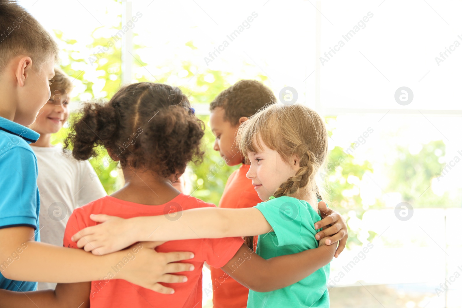 Photo of Little children making circle with hands around each other indoors. Unity concept