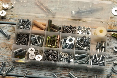 Organizer with many different fasteners on rustic wooden table, above view