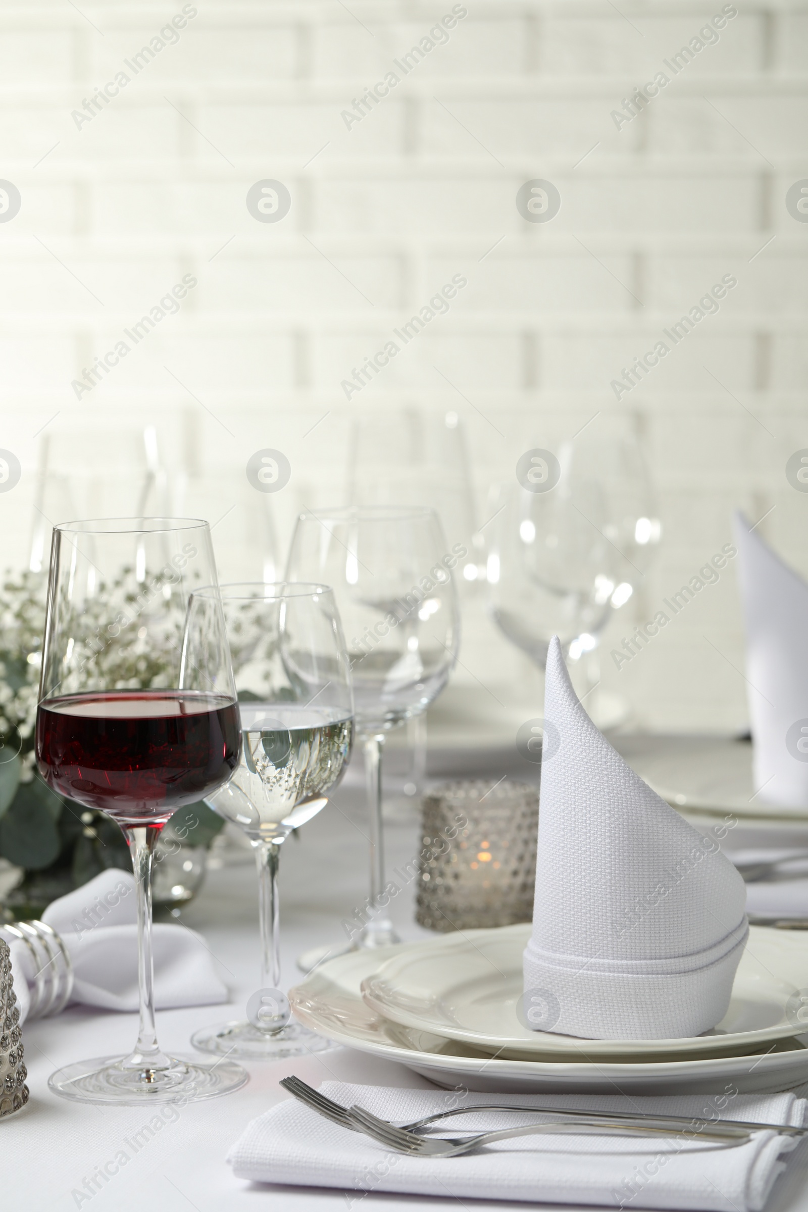 Photo of Glass of delicious wine and elegant table setting in restaurant