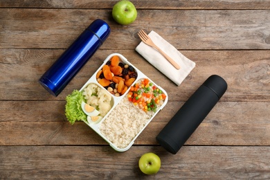 Photo of Flat lay composition with thermoses and food on wooden table