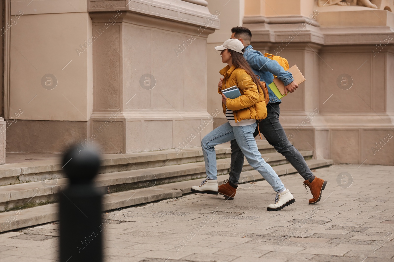 Photo of Being late. Students running towards building outdoors, space for text