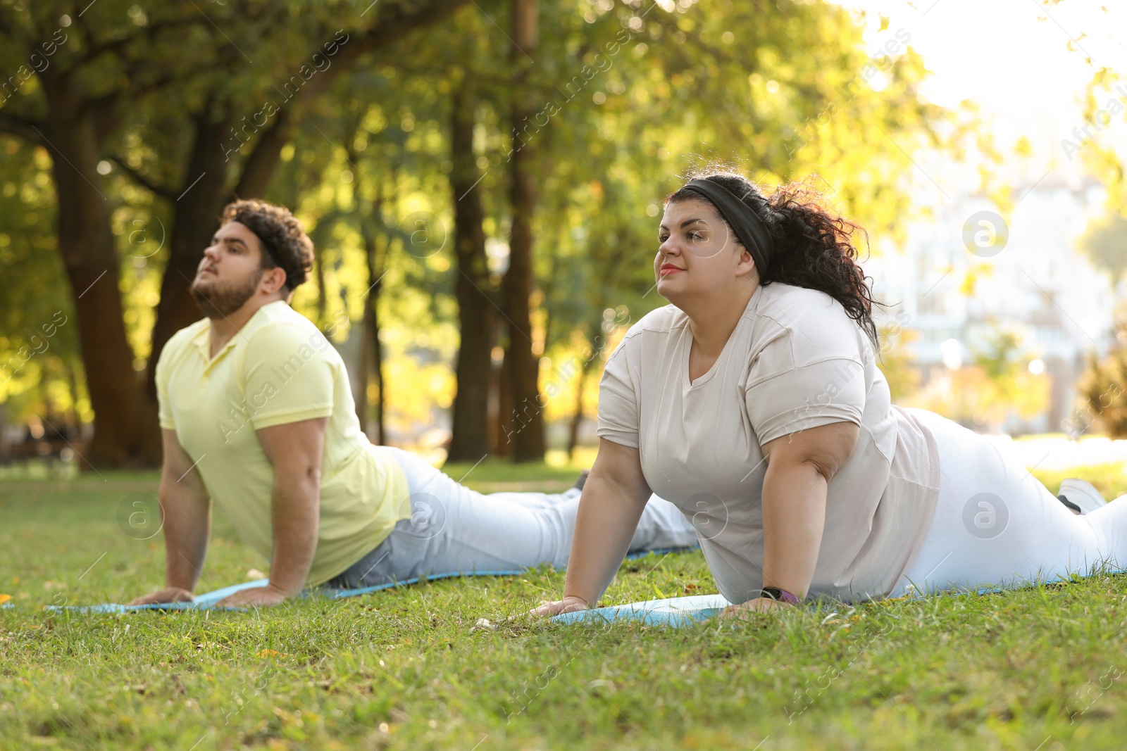 Photo of Overweight couple training together in park on sunny day