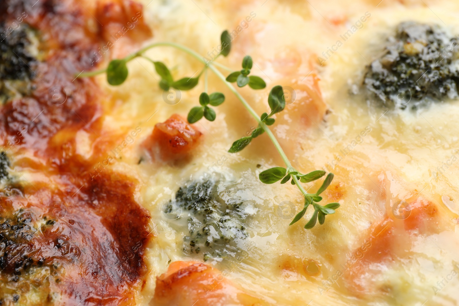 Photo of Delicious homemade quiche with salmon and broccoli as background, top view