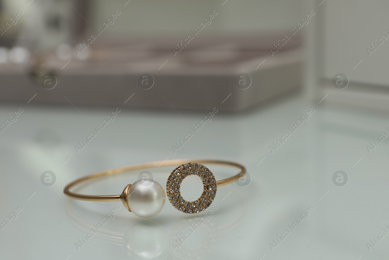 Photo of Elegant golden bracelet with pearl and diamonds on white table