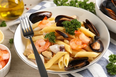 Photo of Delicious pasta with sea food served on white wooden table