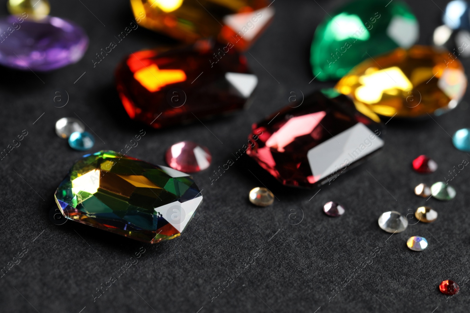 Photo of Beautiful gemstones for jewelry on dark background, closeup