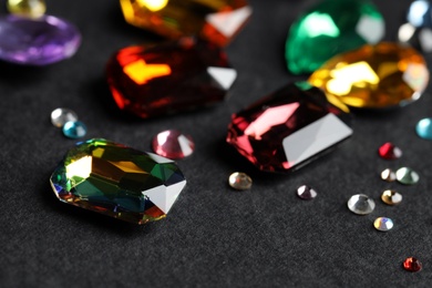Photo of Beautiful gemstones for jewelry on dark background, closeup
