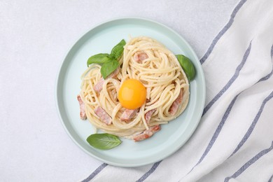 Photo of Delicious pasta Carbonara with egg yolk on white table, top view