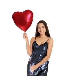 Portrait of young woman with heart shaped balloon on white background