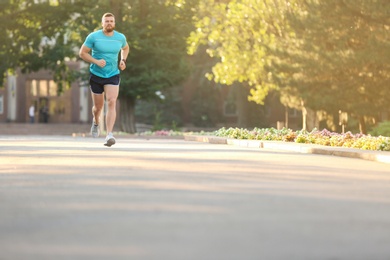 Photo of Young man running in park on sunny day