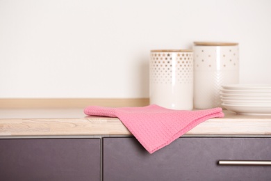 Fabric pink towel on wooden table in kitchen