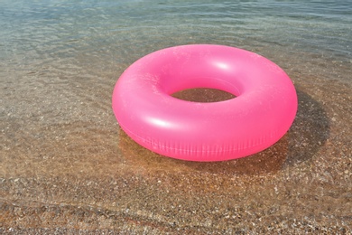 Photo of Bright inflatable ring floating on sea water. Summer vacation