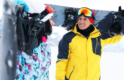 Photo of Lovely couple with snowboards on hill. Winter vacation
