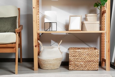 Photo of Wooden shelving unit with home decor near light wall