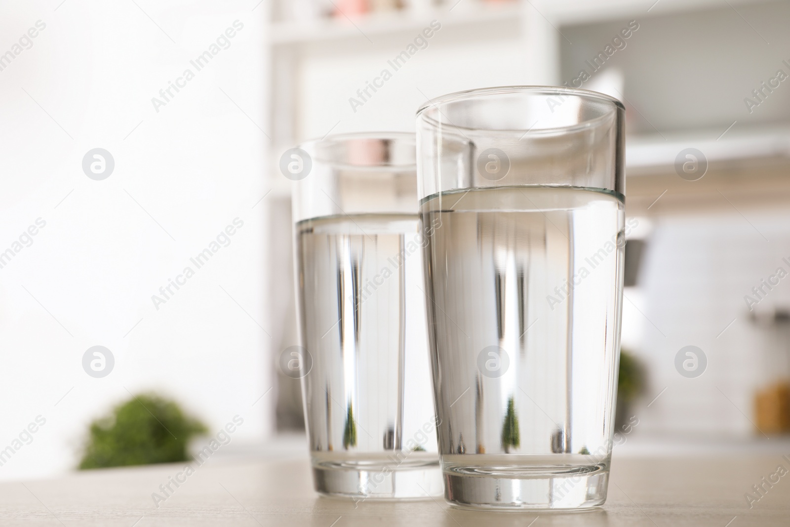 Photo of Glasses of fresh water on table indoors