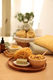 Photo of Dry flowers, loofah and soap bar on wooden table indoors, space for text. Spa time