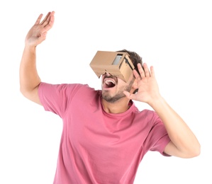 Photo of Young man using cardboard virtual reality headset, isolated on white