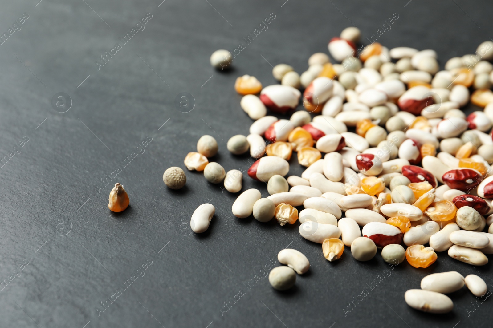 Photo of Mixed vegetable seeds on grey background, closeup
