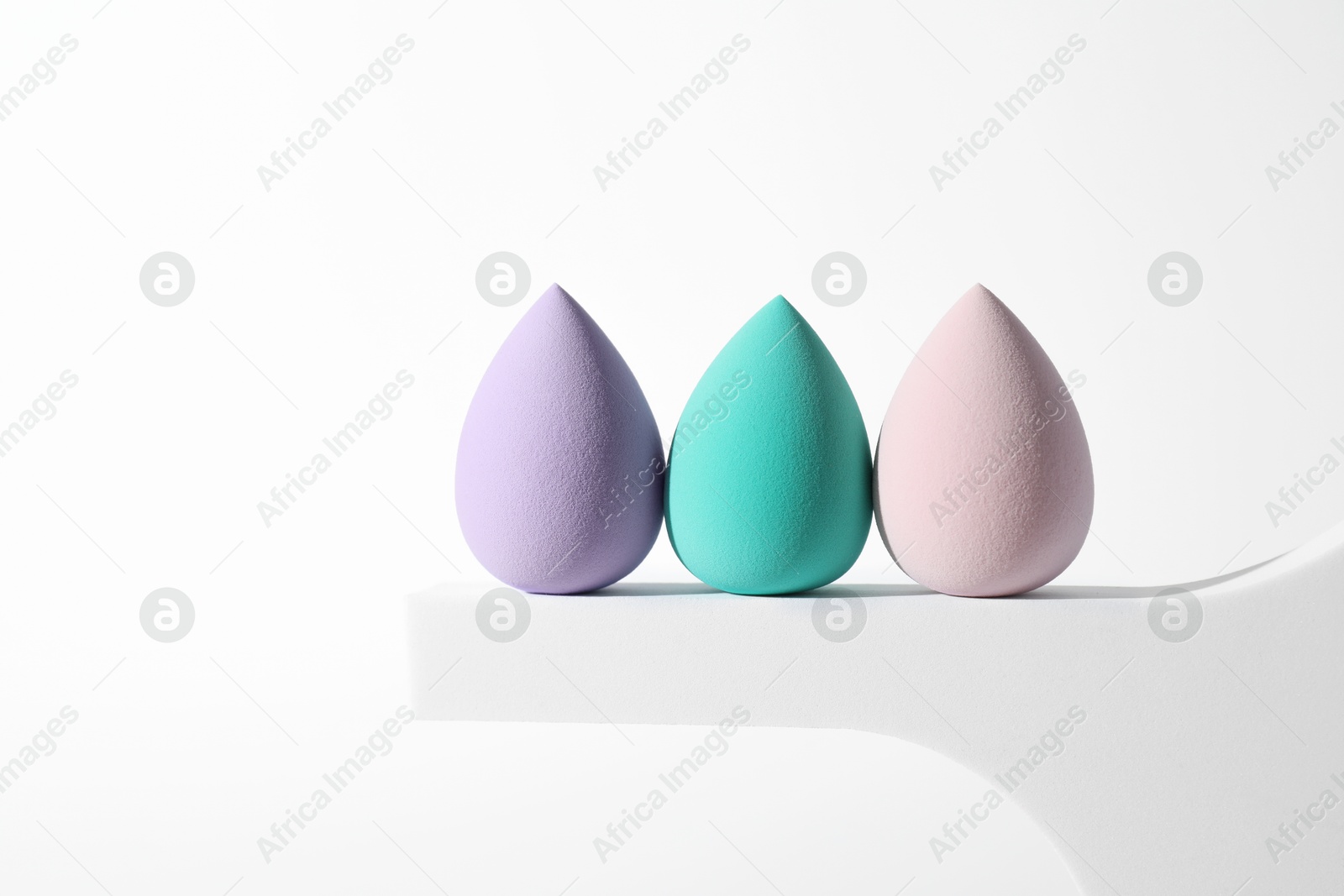 Photo of Stylish presentation of makeup sponges on white background, space for text