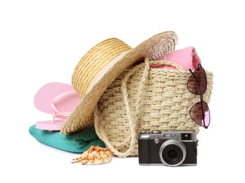 Stylish bag with beach accessories and camera isolated on white