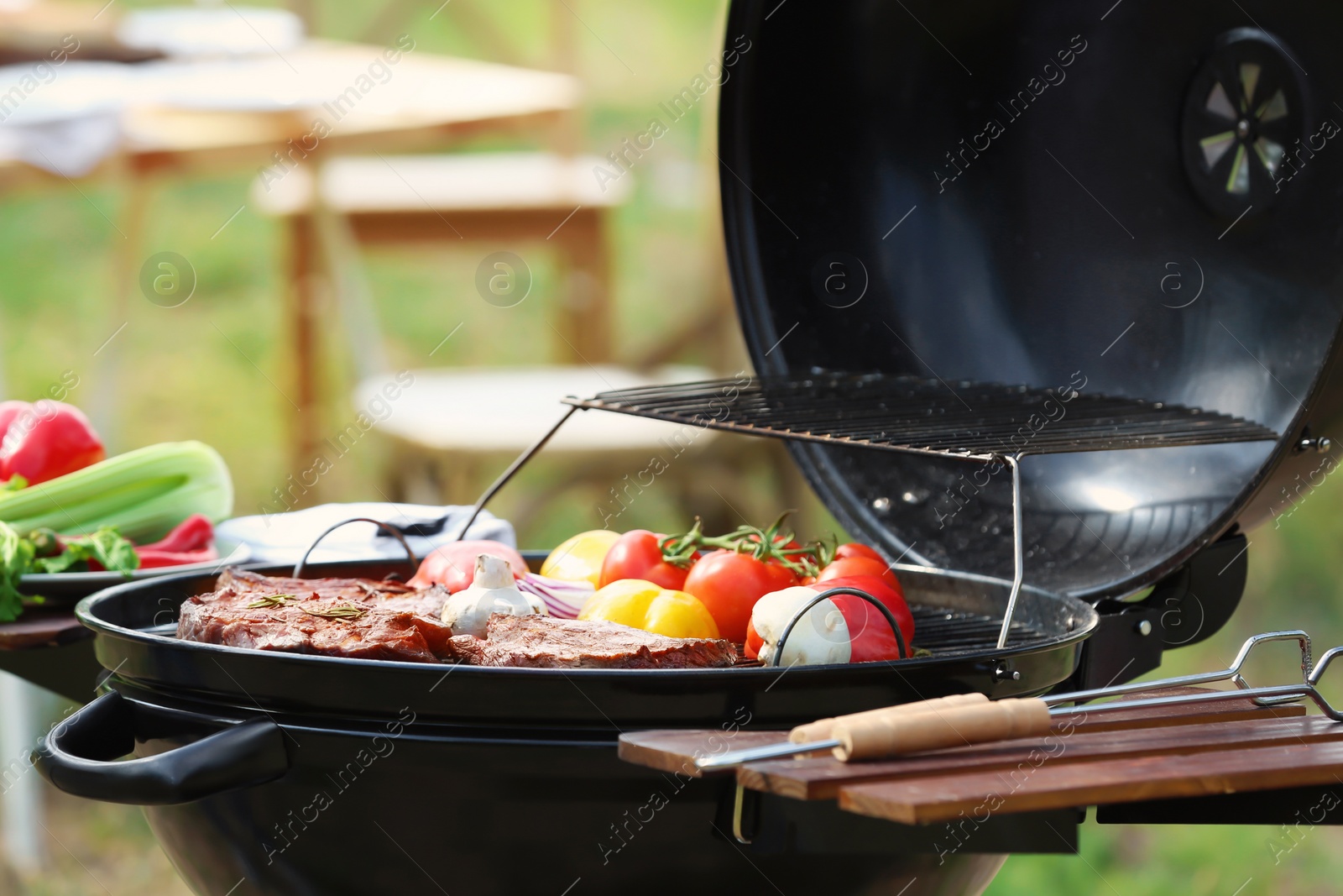 Photo of Barbecue grill with meat and vegetables outdoors, closeup