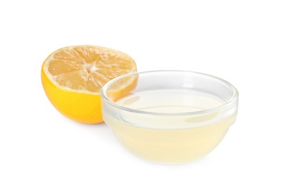 Freshly squeezed juice and half of lemon on white background