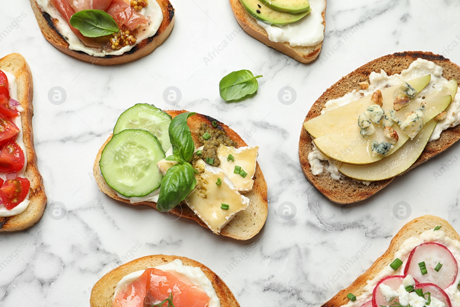 Photo of Different tasty bruschettas on marble background, flat lay