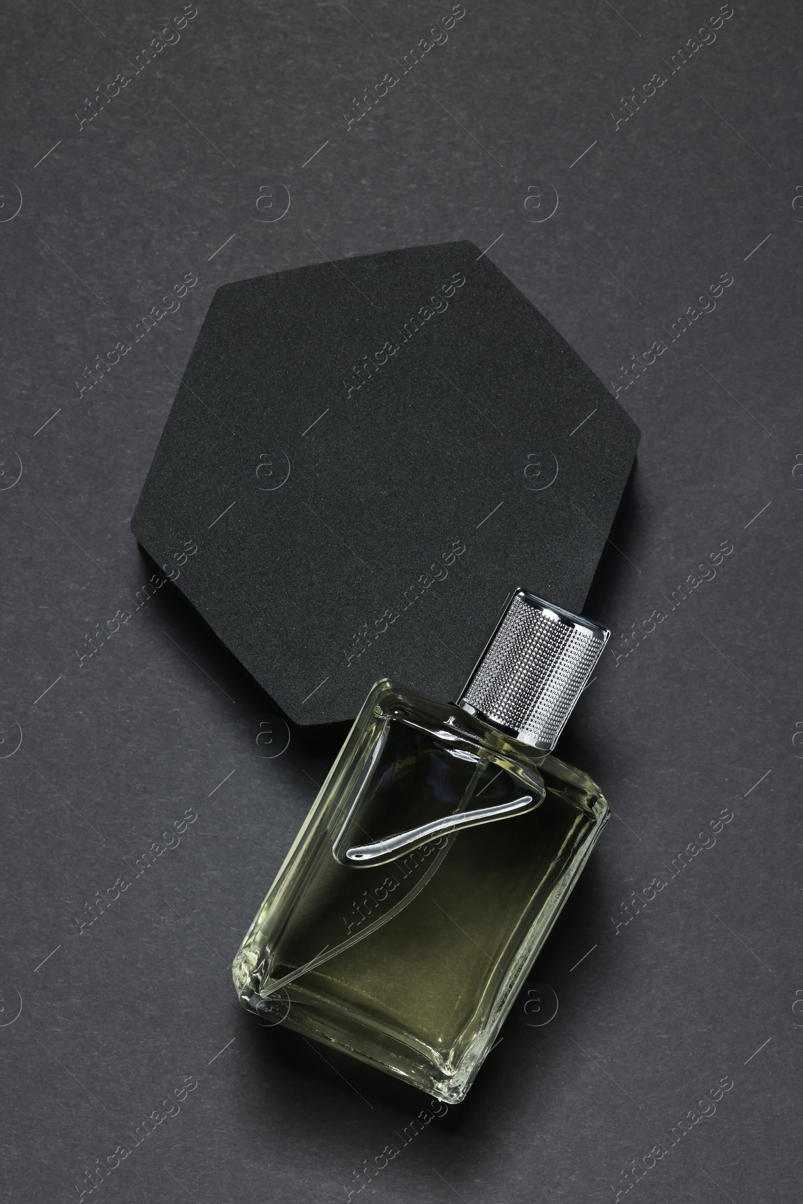 Photo of Stylish presentation of luxury men`s perfume in bottle on black background, top view