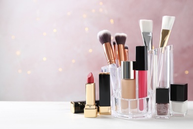 Photo of Makeup cosmetic products on white wooden table against pink background, space for text