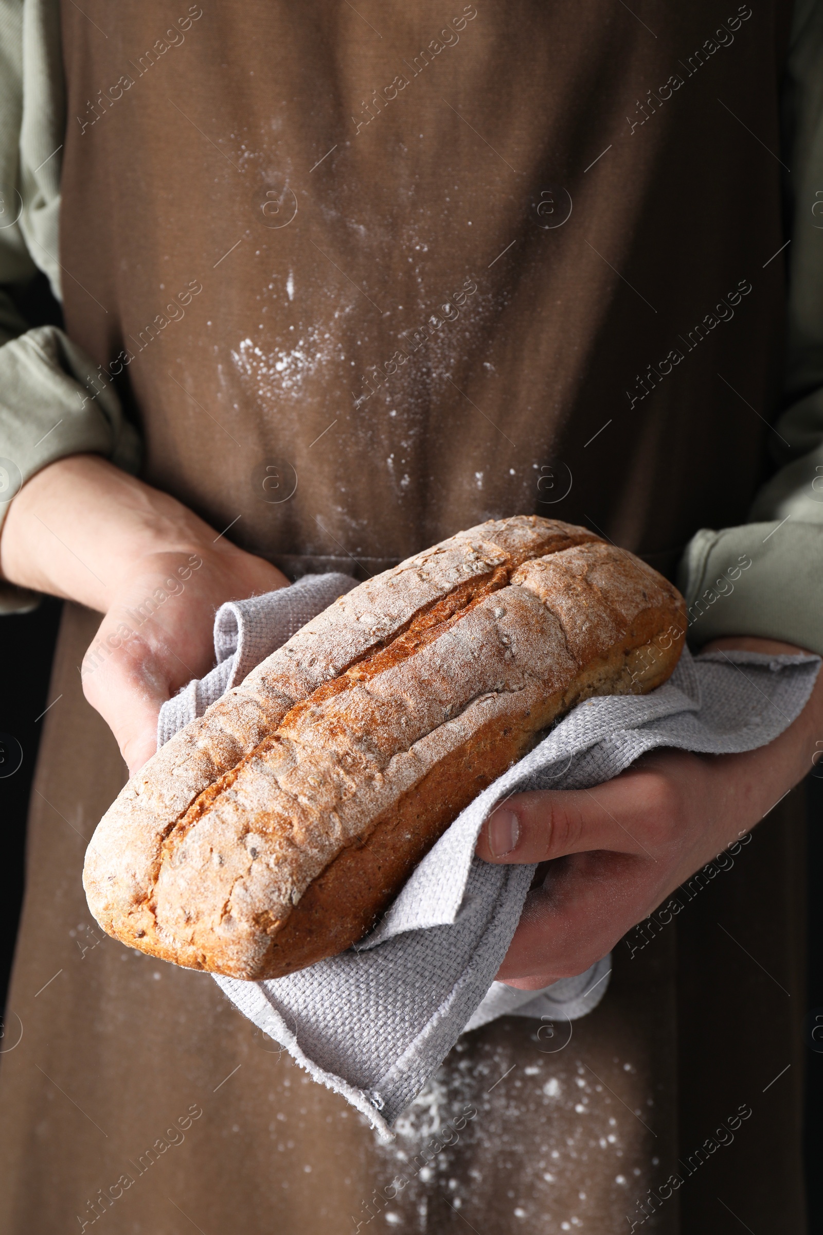 Photo of Woman holding one freshly baked bread, closeup