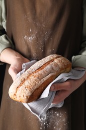 Photo of Woman holding one freshly baked bread, closeup