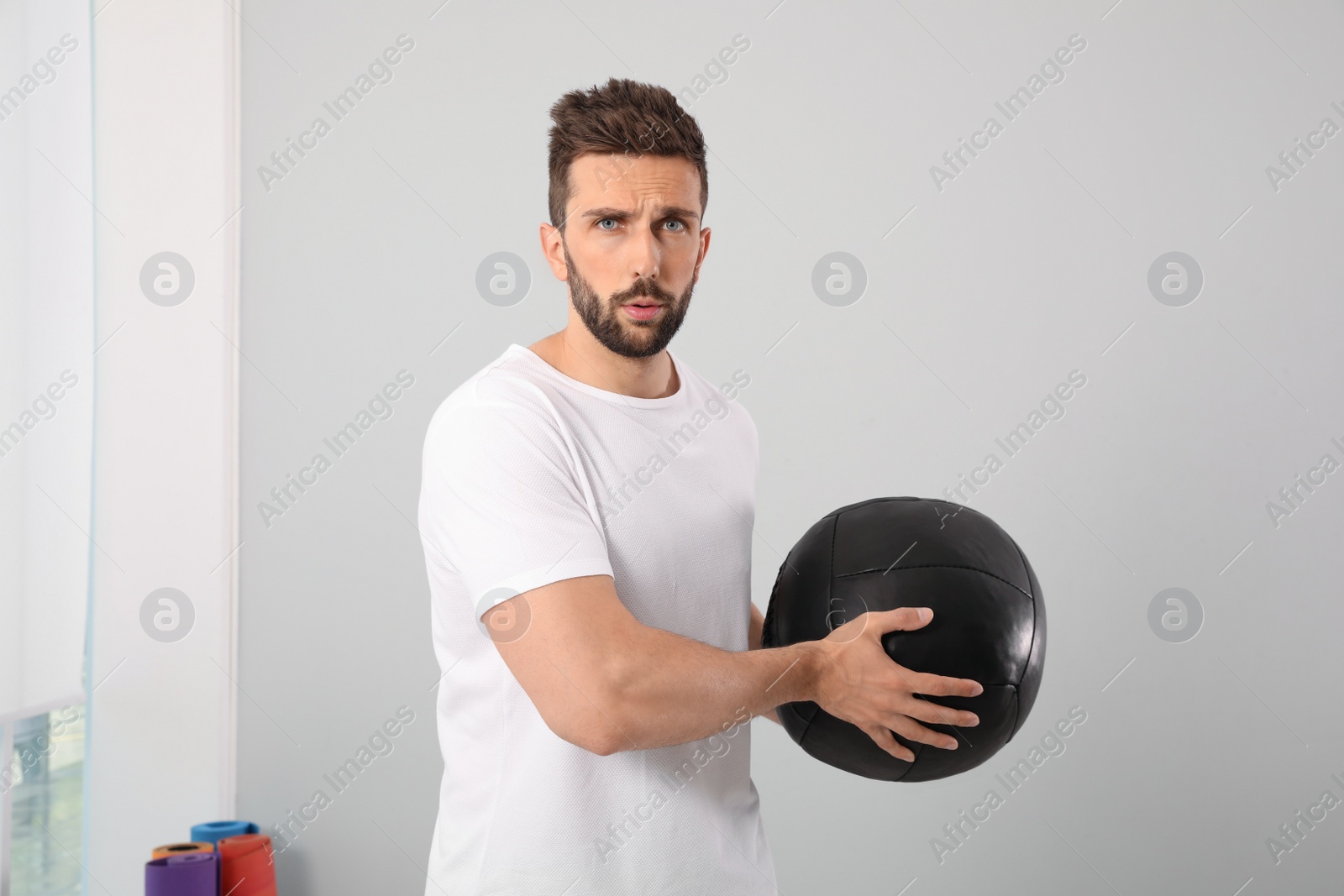 Photo of Athletic man with medicine ball in modern gym