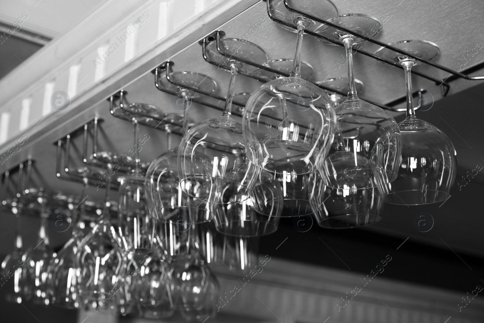 Photo of Set of empty clean glasses on bar racks