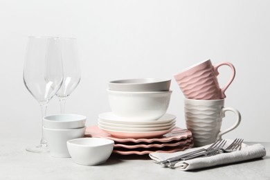 Photo of Beautiful ceramic dishware, cups, glasses and cutlery on light grey table