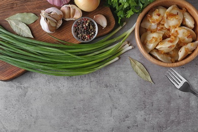 Photo of Delicious cooked dumplings with fried onion on grey table, flat lay. Space for text