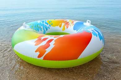 Photo of Bright inflatable ring floating on sea water. Summer vacation