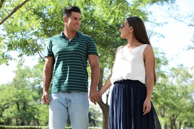 Lovely couple walking together in park on sunny day