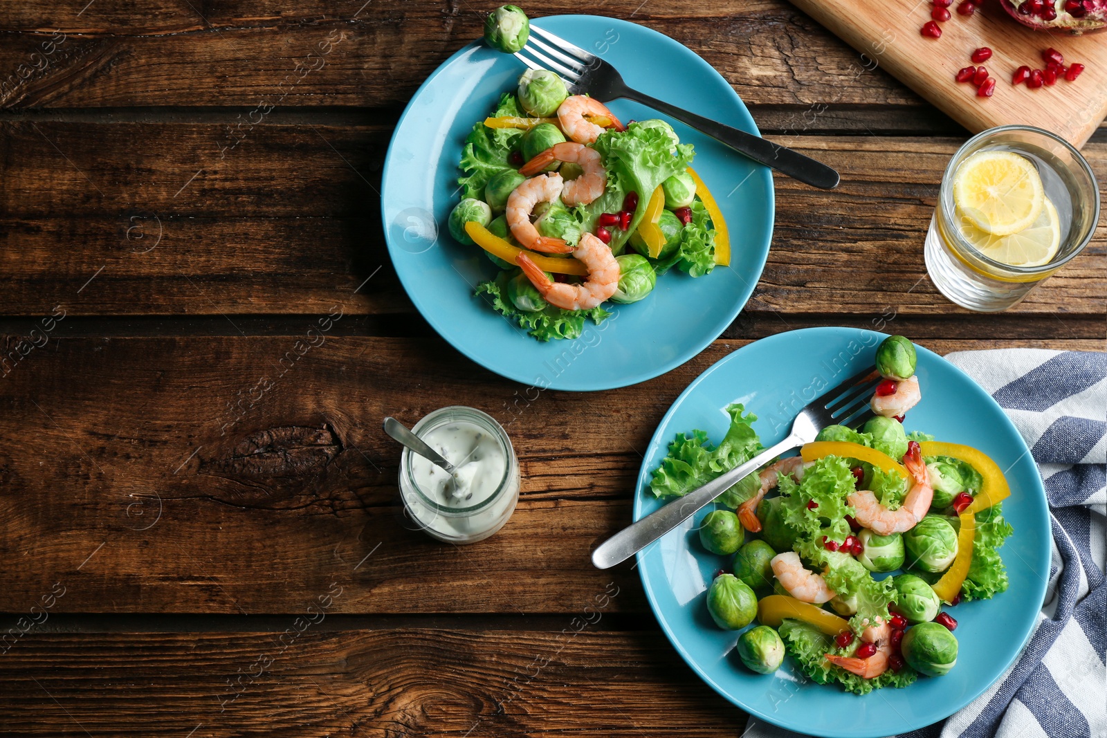 Photo of Tasty salad with Brussels sprouts served on wooden table, flat lay