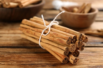 Aromatic cinnamon sticks on wooden table, closeup