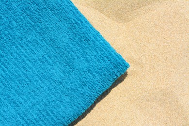 Soft blue beach towel on sand, top view. Space for text