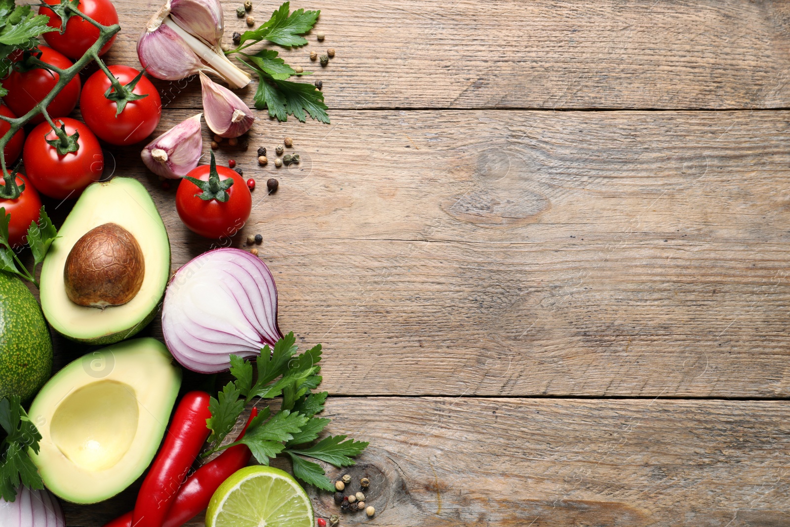 Photo of Fresh guacamole ingredients on wooden table, flat lay. Space for text