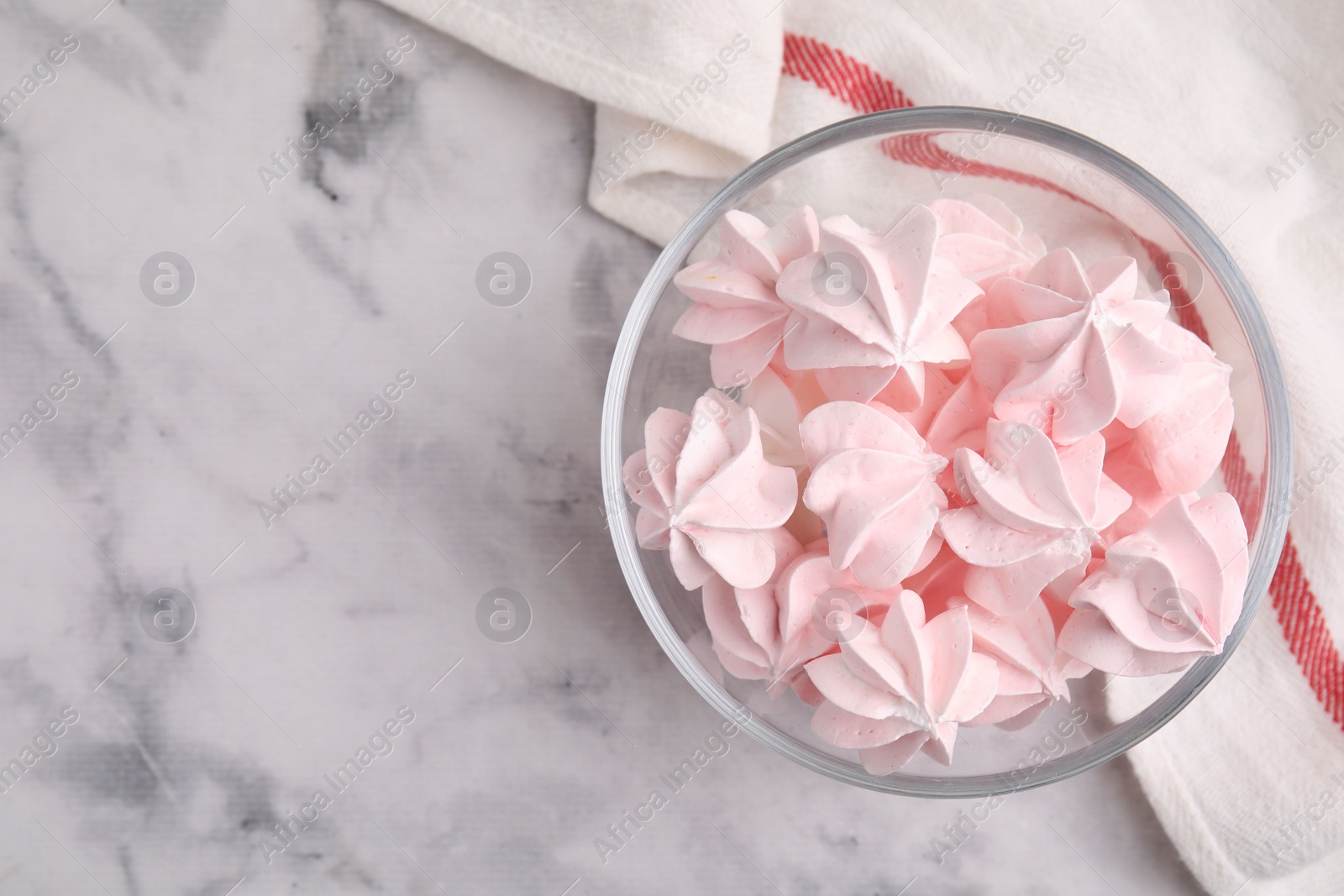 Photo of Tasty meringue cookies in bowl on white marble table, top view. Space for text