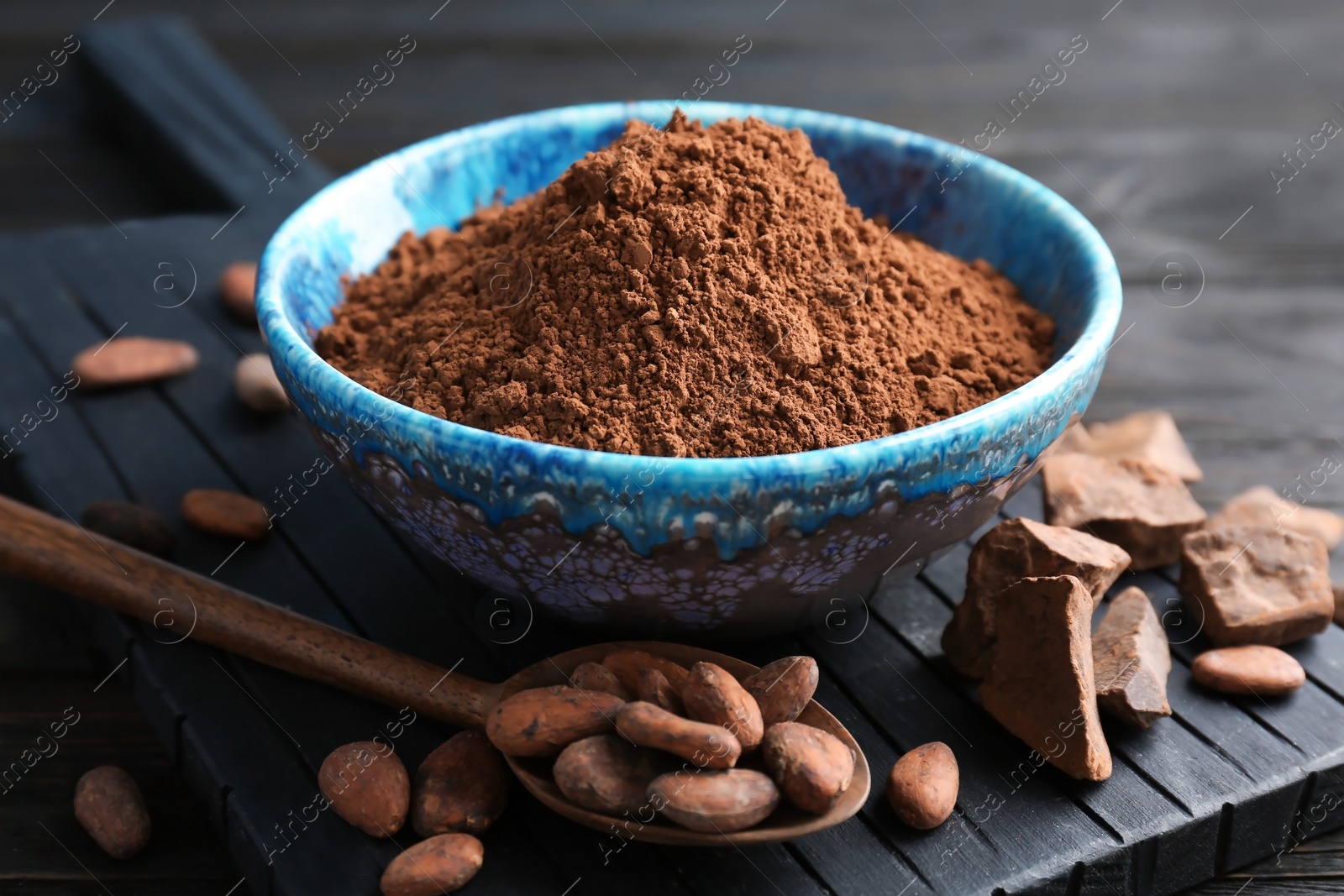 Photo of Composition with cocoa powder and beans on wooden board