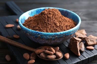 Composition with cocoa powder and beans on wooden board